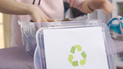 Umweltfreundliche-Frau-Wirft-Kleidung-In-Den-Recyclingbehälter.